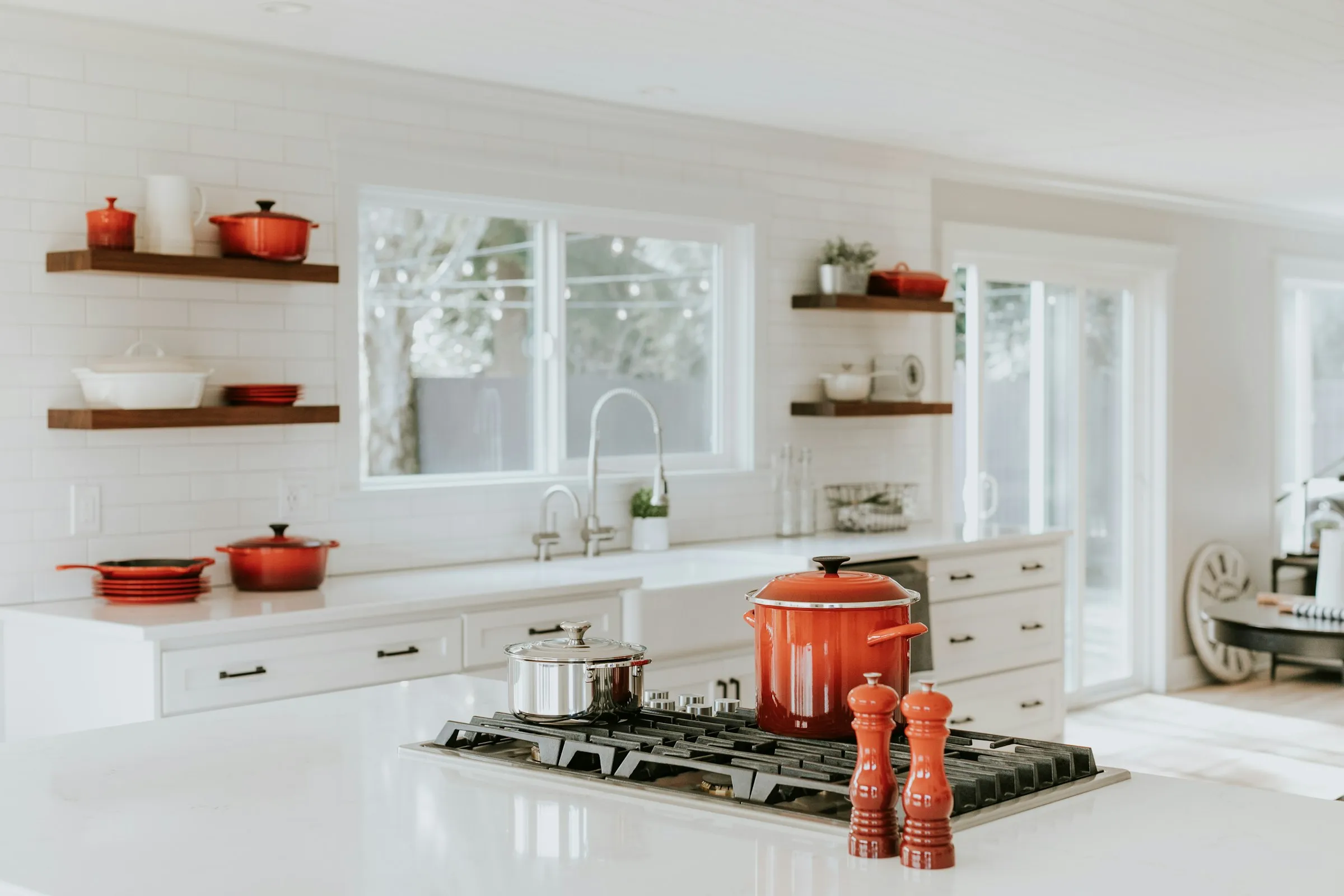 Cocina blanca con baldas de madera y vajilla de color