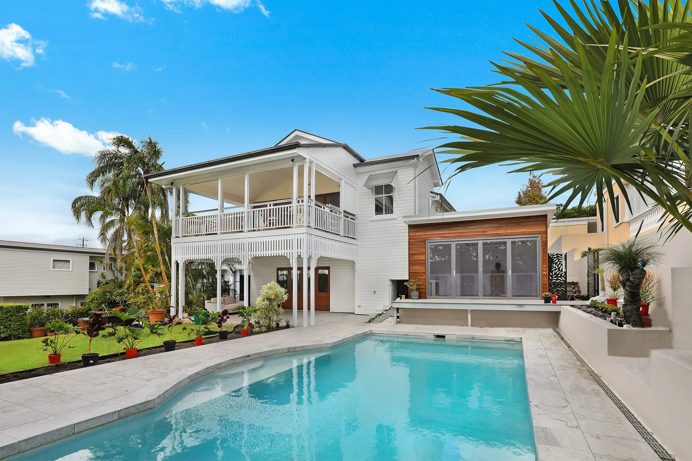 Casa blanca con piscina, tumbonas y palmeras