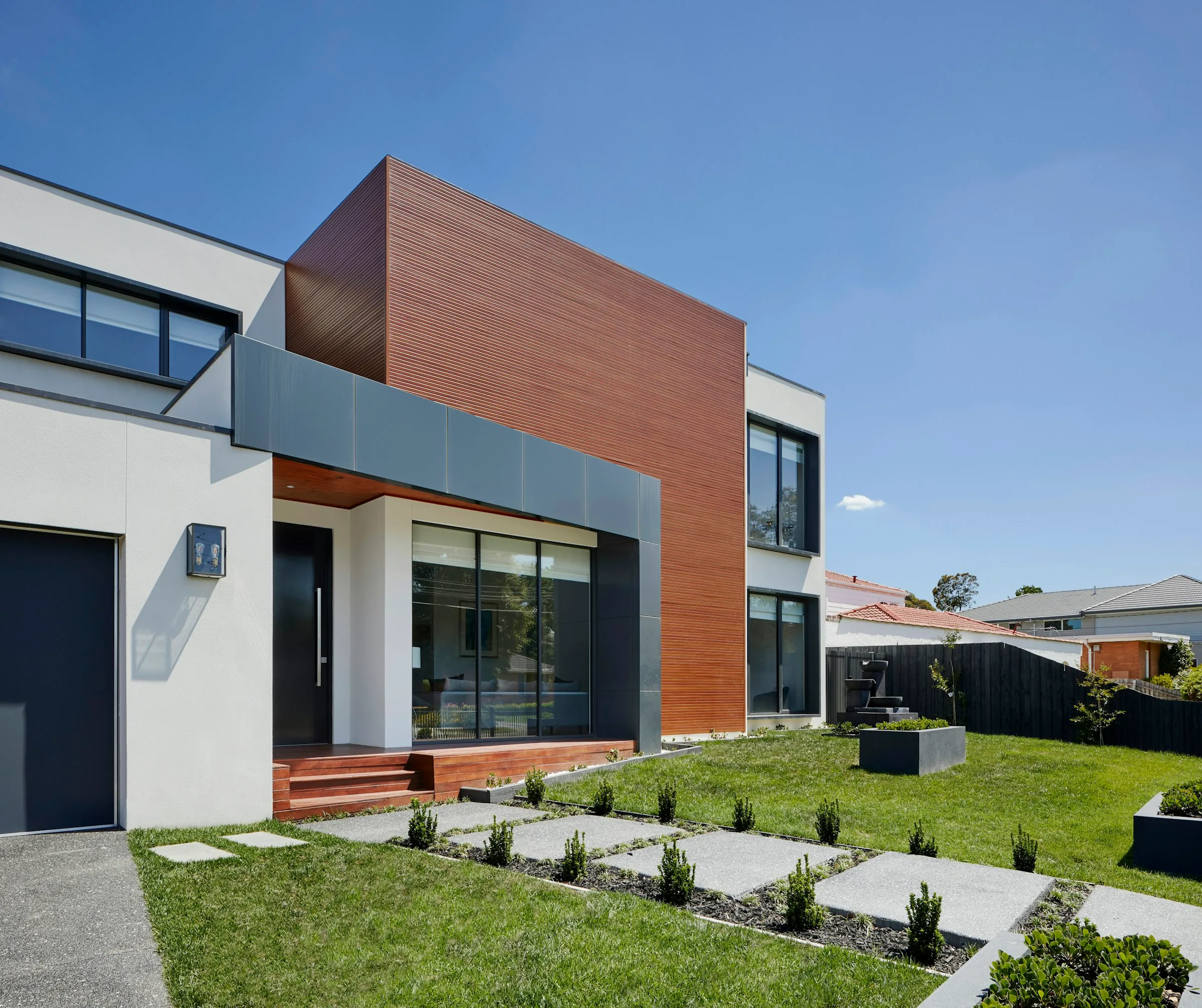 Vivienda contemporanea de una planta con revestimiento de madera y cesped