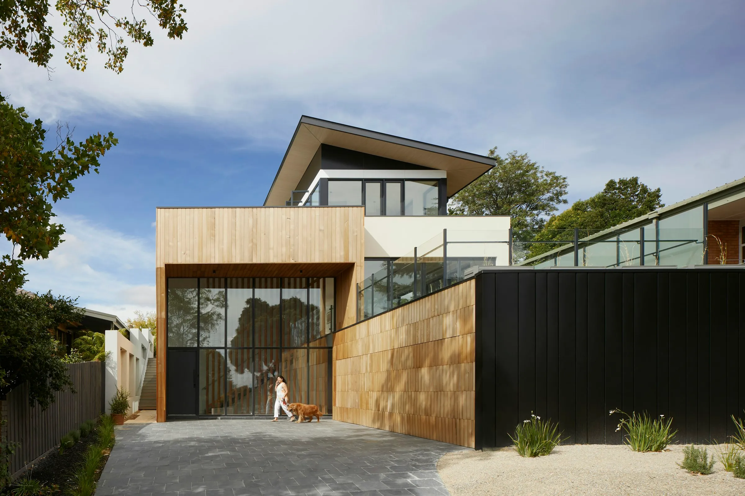 Casa moderna con revestimiento de madera y muro oscuro