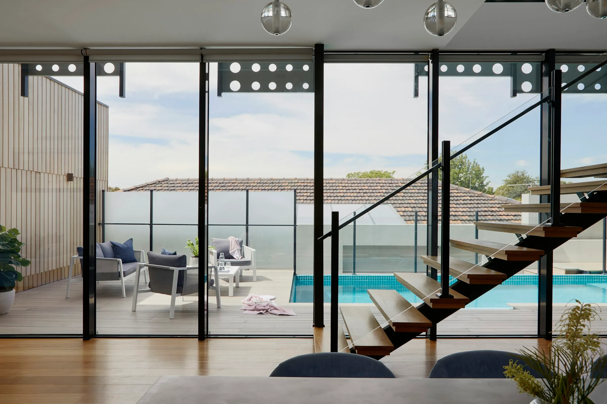 Interior abierto a una terraza con piscina y vistas al mar