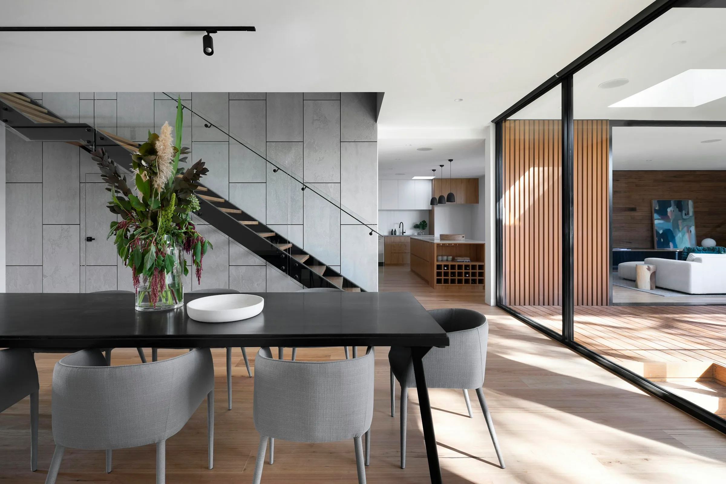 Comedor moderno junto a una escalera de peldanos volados