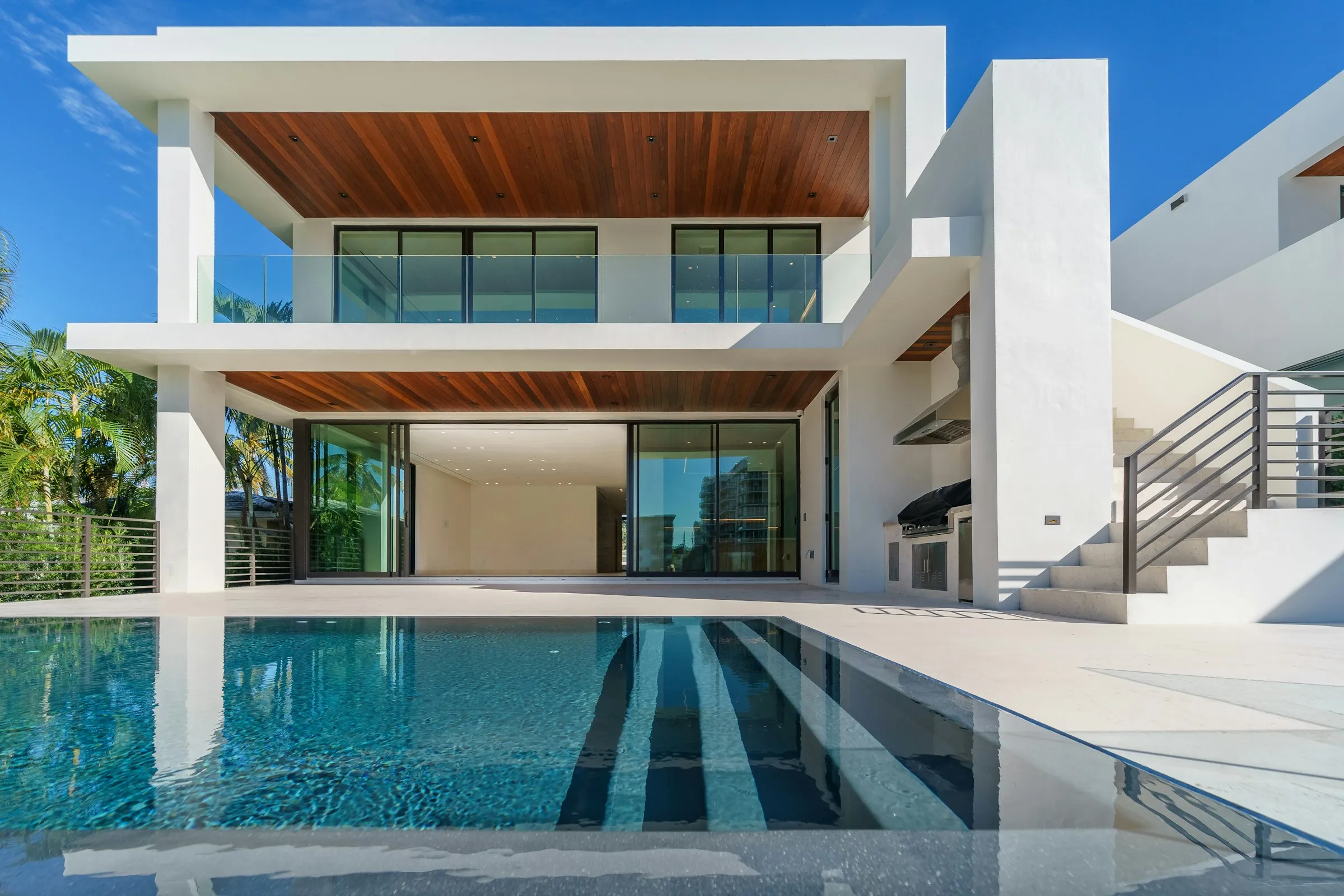 Casa de dos plantas con techo de madera y piscina de nado